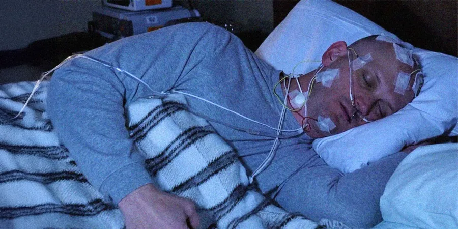 Man undergoing an overnight sleep study with electrodes attached